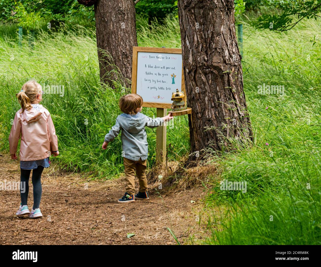 Niños pequeños siguiendo el sendero de hadas, Archerfield Estate, East Lothian, Escocia, Reino Unido Foto de stock