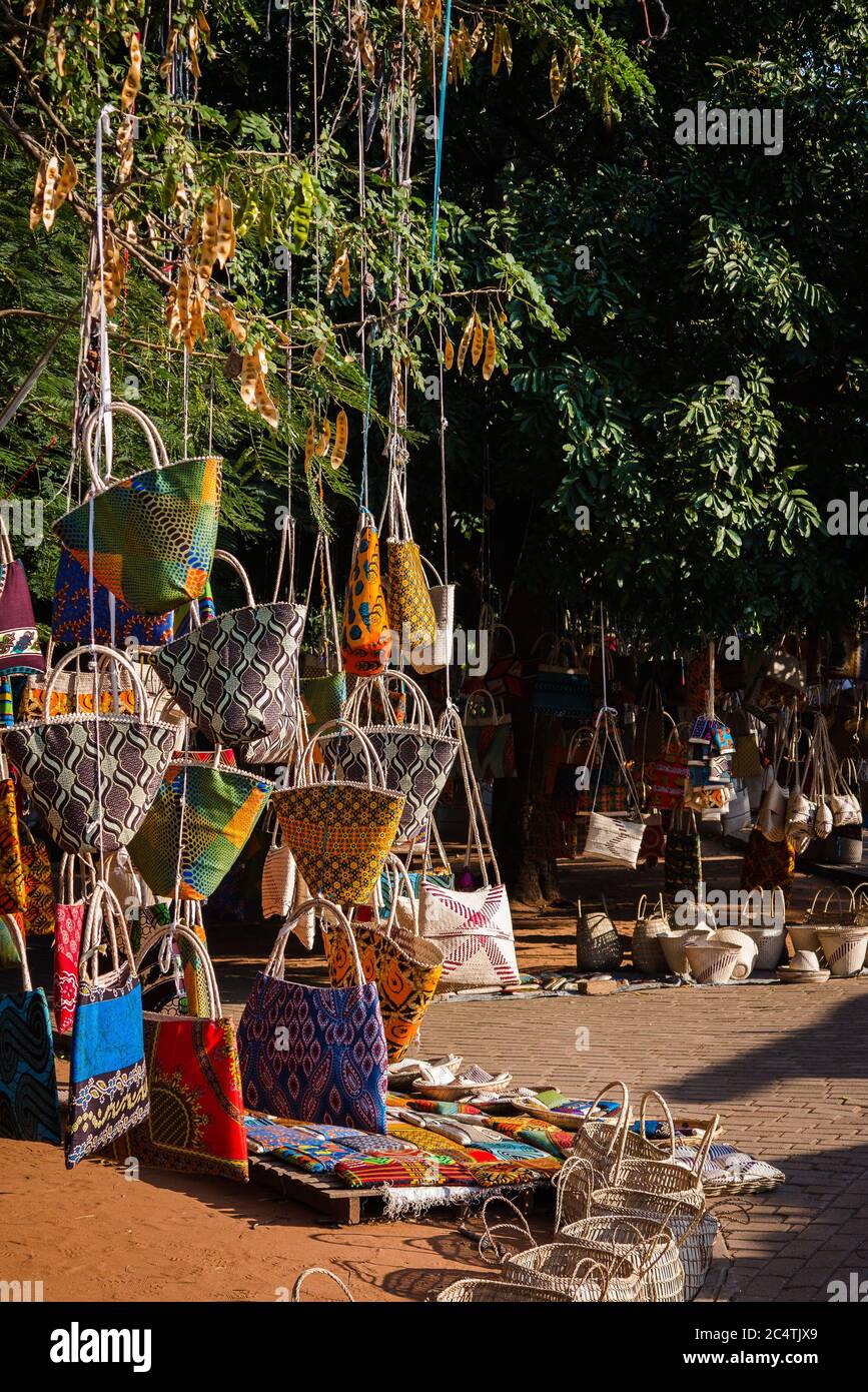 Coloridos bolsos colgados de un árbol en el mercado de pulgas FEIMA en Maputo, Mozambique Foto de stock