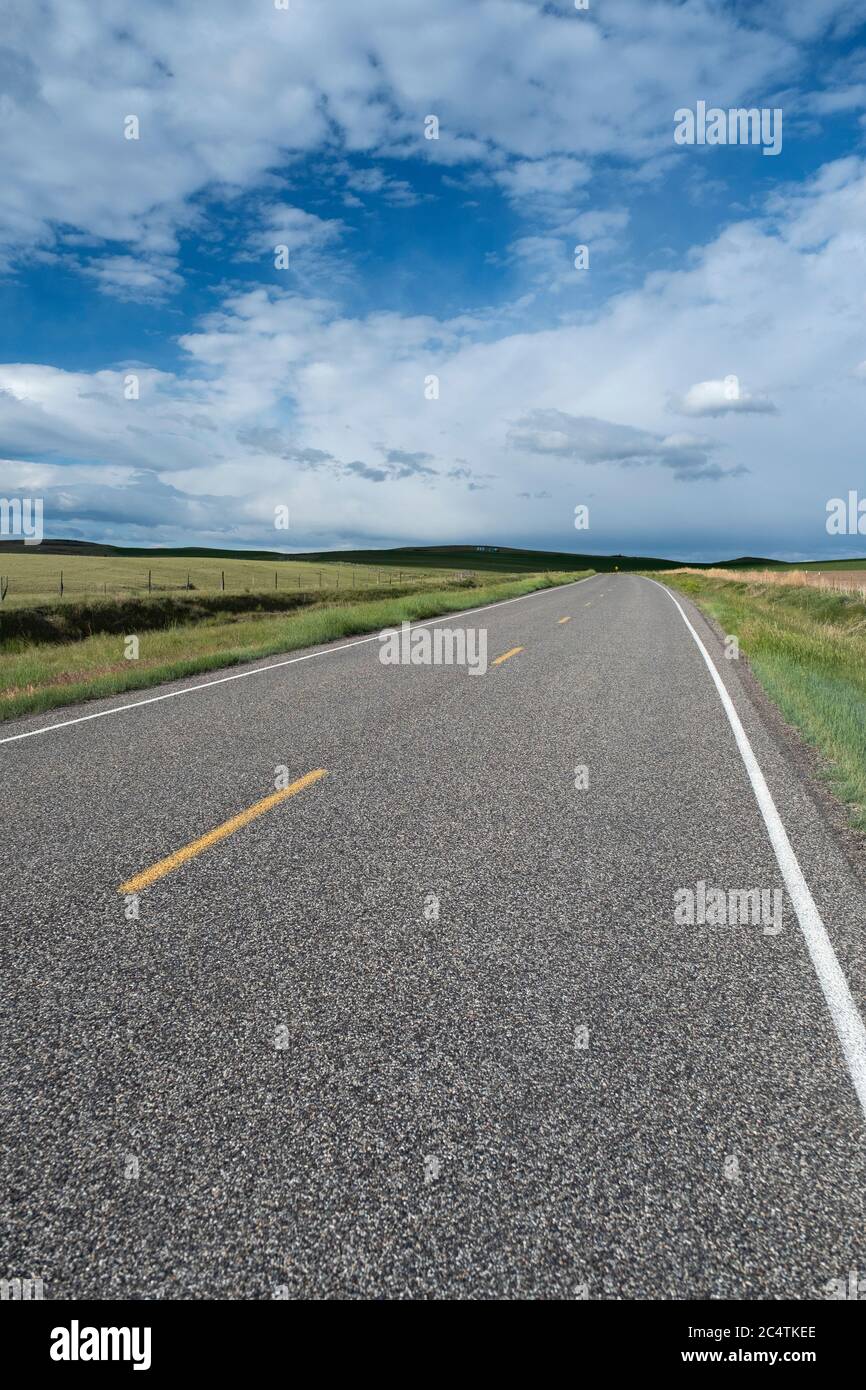 Escénica carretera rural bajo un famoso Big Sky, en el condado de Gallatin, Montana Foto de stock