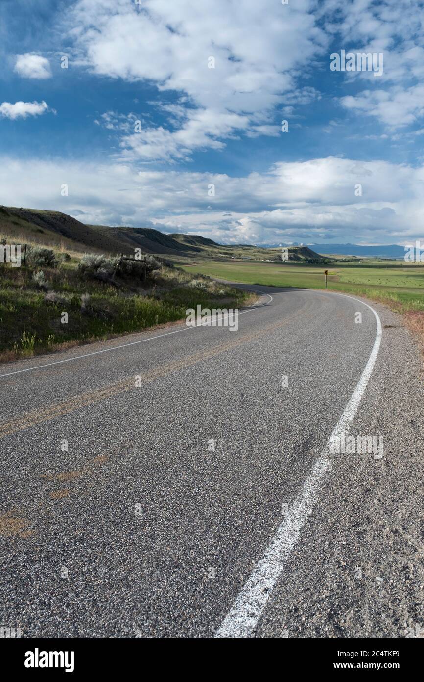 Escénica carretera rural bajo un famoso Big Sky, en el condado de Gallatin, Montana Foto de stock