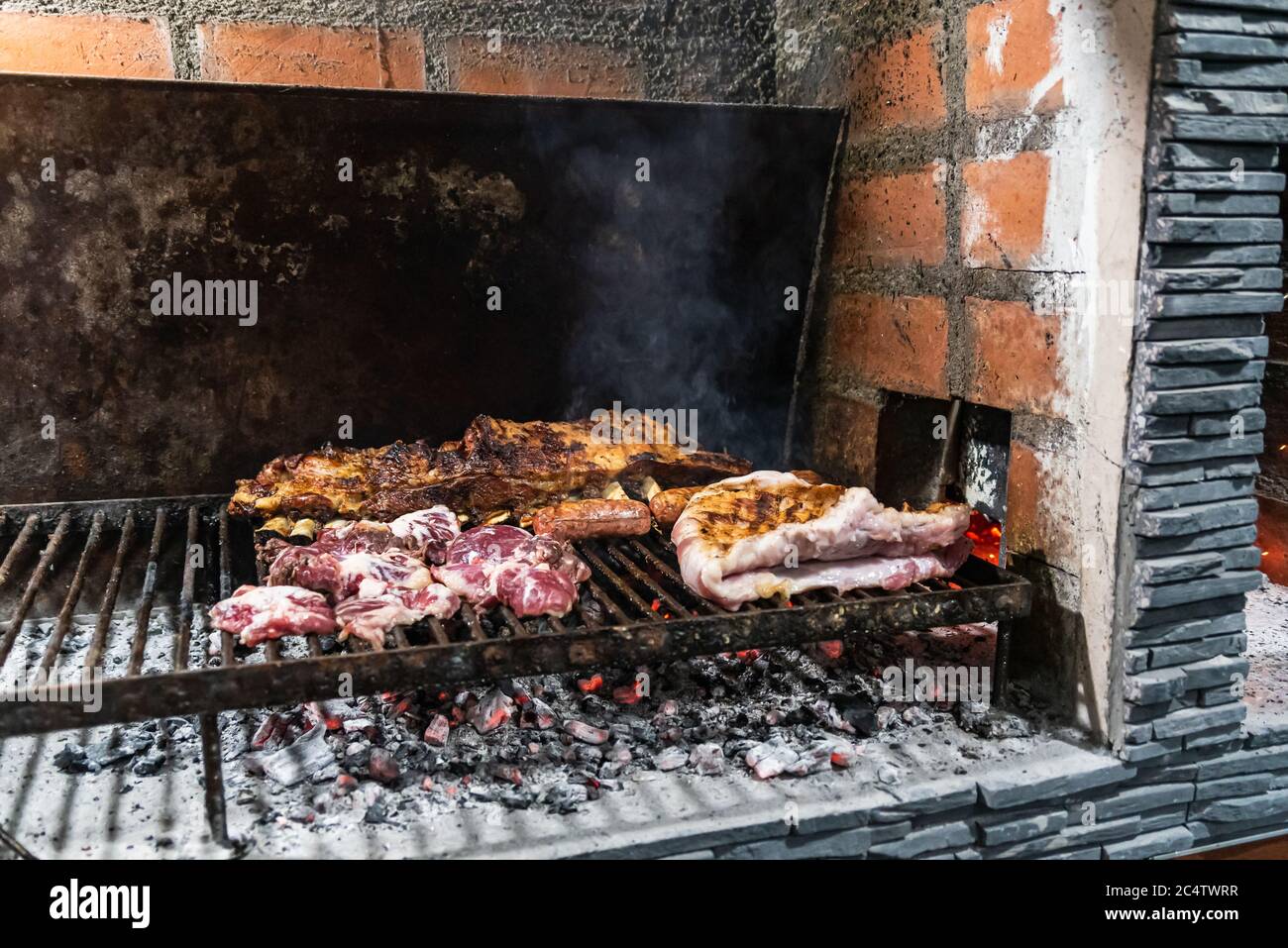 Parrillada' barbacoa Argentina hacer sobre carbón vivo (sin llama), carne  'asado', pan, 'Chorizo' y costillas de ternera a la parrilla con un estante  caliente, de cerca, enfoque se Fotografía de stock 