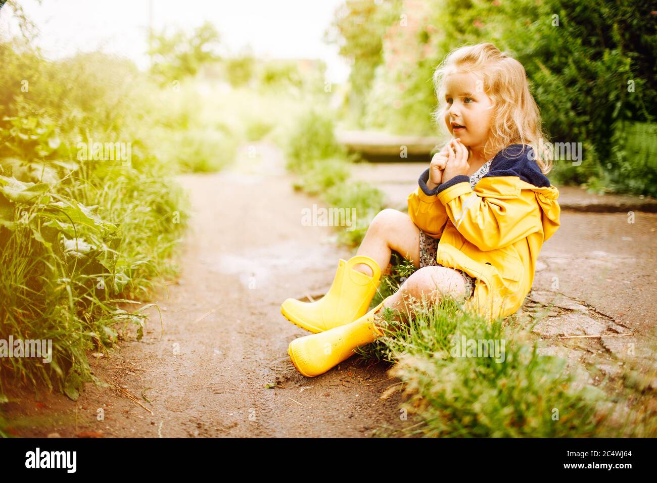 Una niña alegre con una camiseta amarilla se sienta en el suelo con las  piernas dobladas: fotografía de stock © Kulyashina #549053046