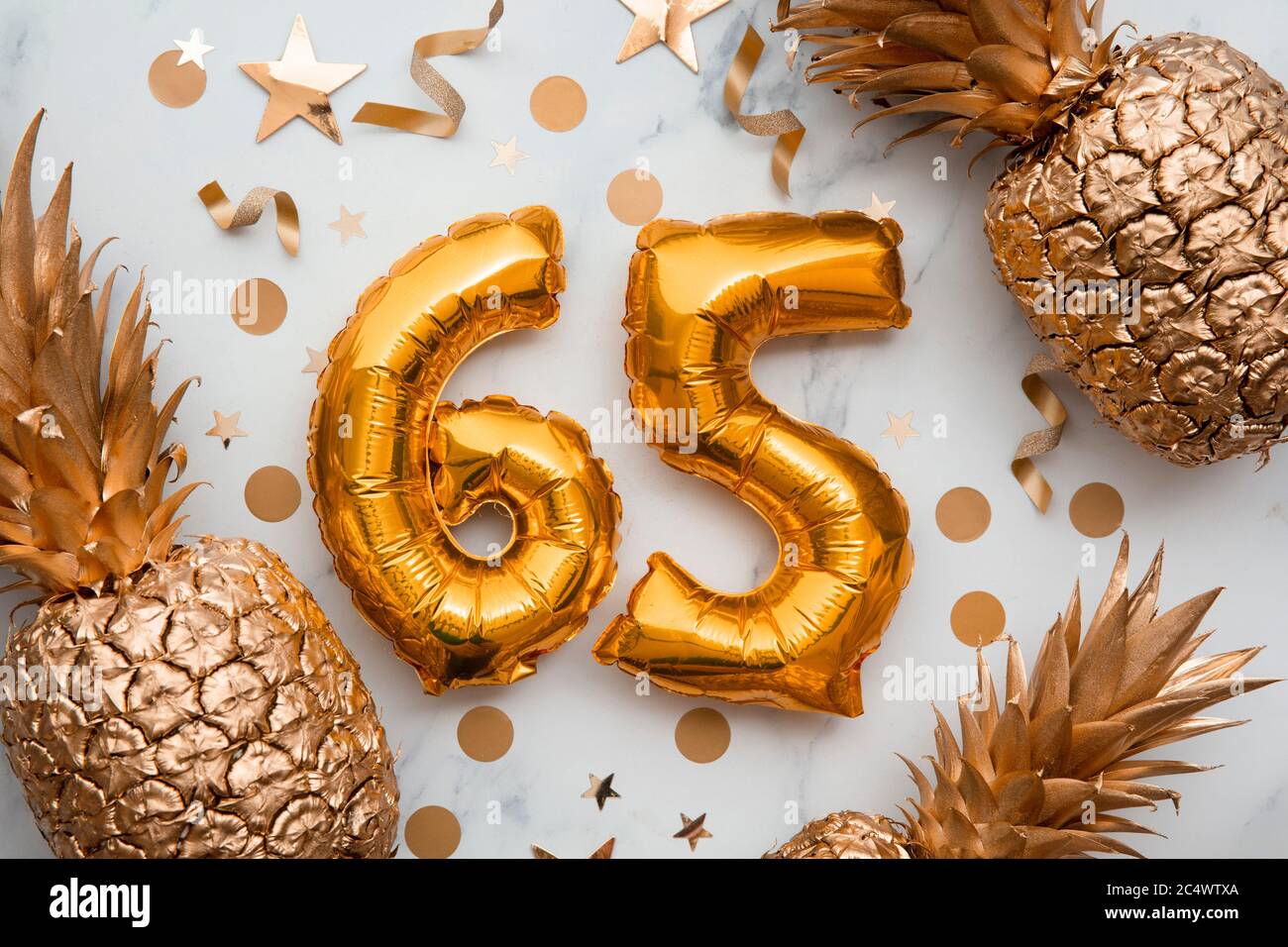 tarjeta de celebración de 65 cumpleaños con globos de papel de aluminio dorado y piñas doradas Foto de stock