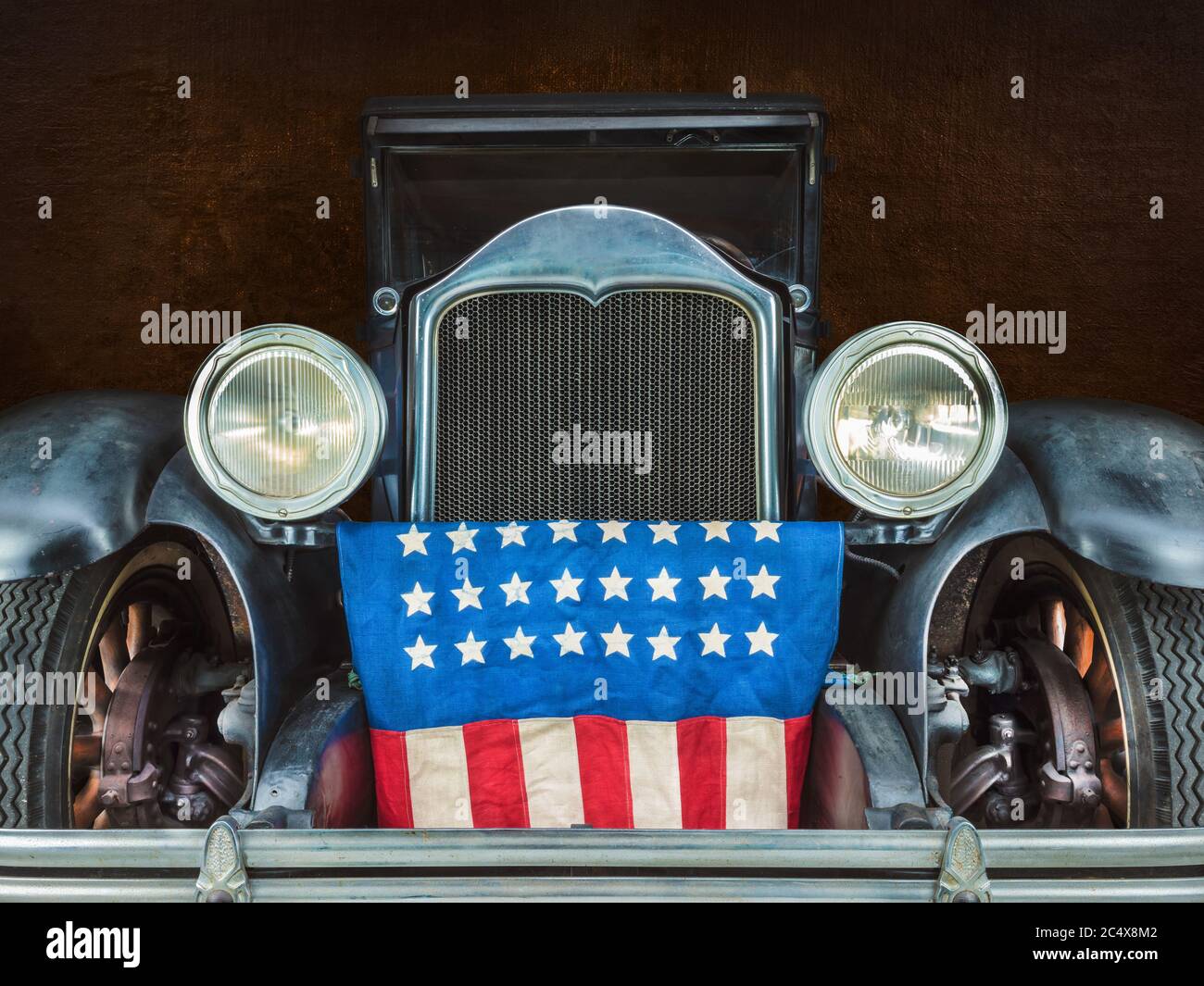 Clásico negro de principios del siglo XX limusina coche con la bandera americana en frente de la rejilla Foto de stock