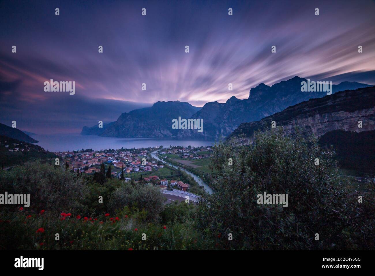 Exposición de larga duración de la puesta de sol de Torbole, un pueblo colorido en Lago di Garda (Lago de Garda), Trentino, Italia; Foto de stock