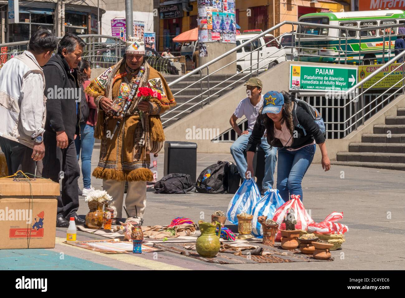 La Paz, Bolivia - 30 de septiembre de 2018: Brujo de medicina tradicional boliviano actúa en la plaza de San Francisco frente a una multitud de telas tradicionales Foto de stock