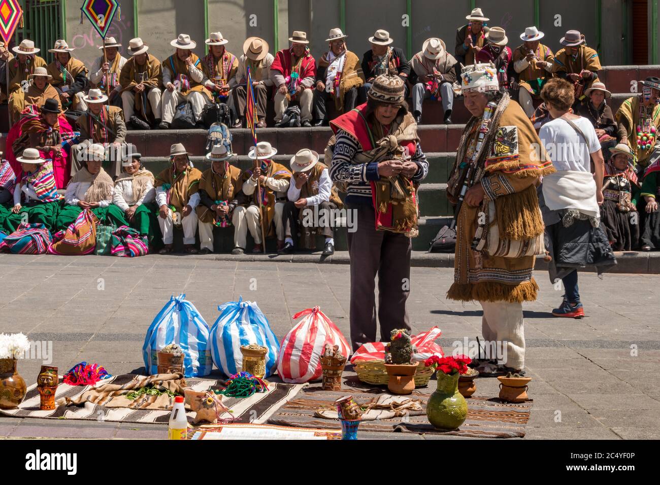 La Paz, Bolivia - 30 de septiembre de 2018: Brujo de medicina tradicional boliviano actúa en la plaza de San Francisco frente a una multitud de telas tradicionales Foto de stock