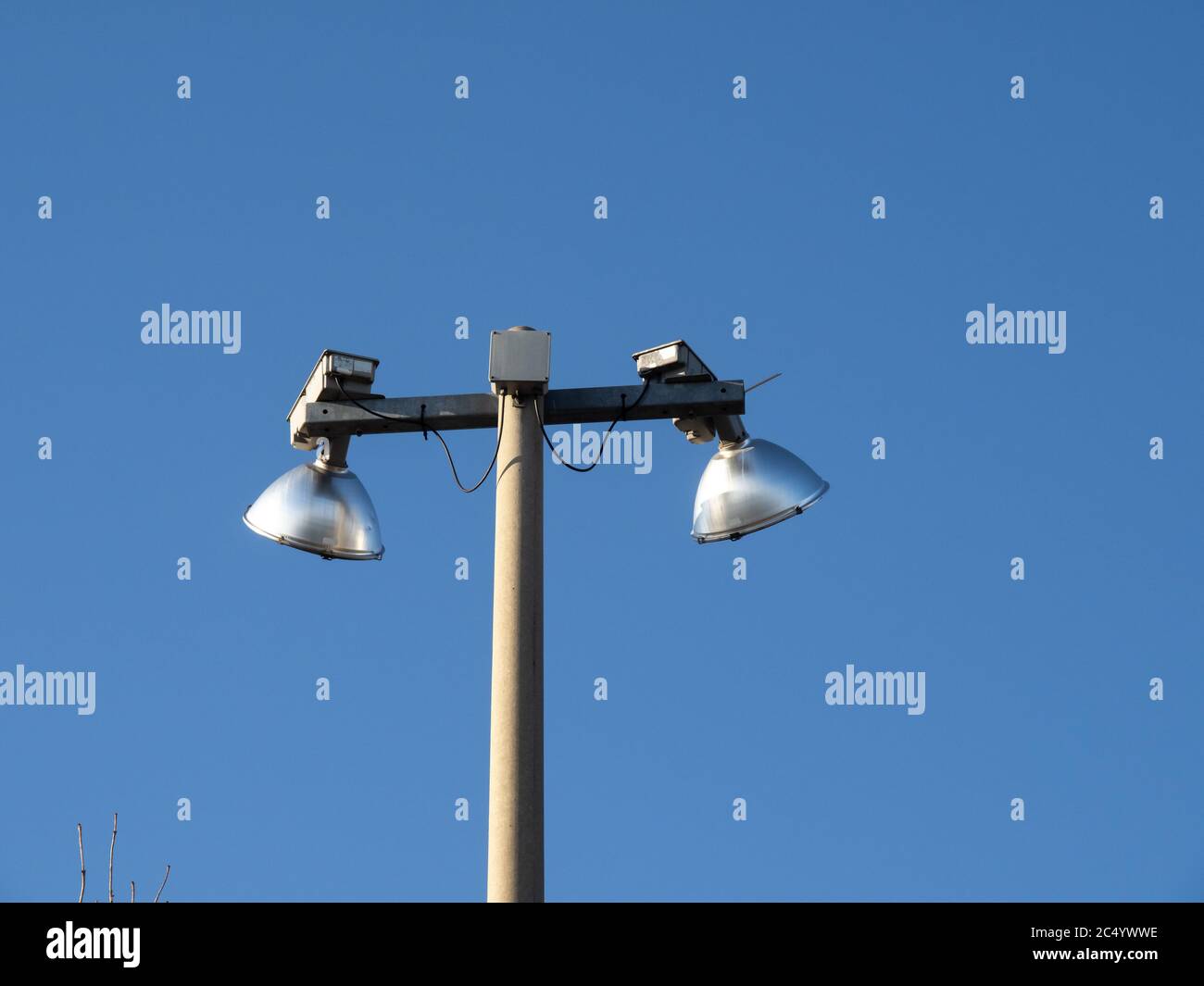 dos luces de vapor de mercurio en el estadio en la parte superior de un  poste de concreto contra un cielo azul Fotografía de stock - Alamy