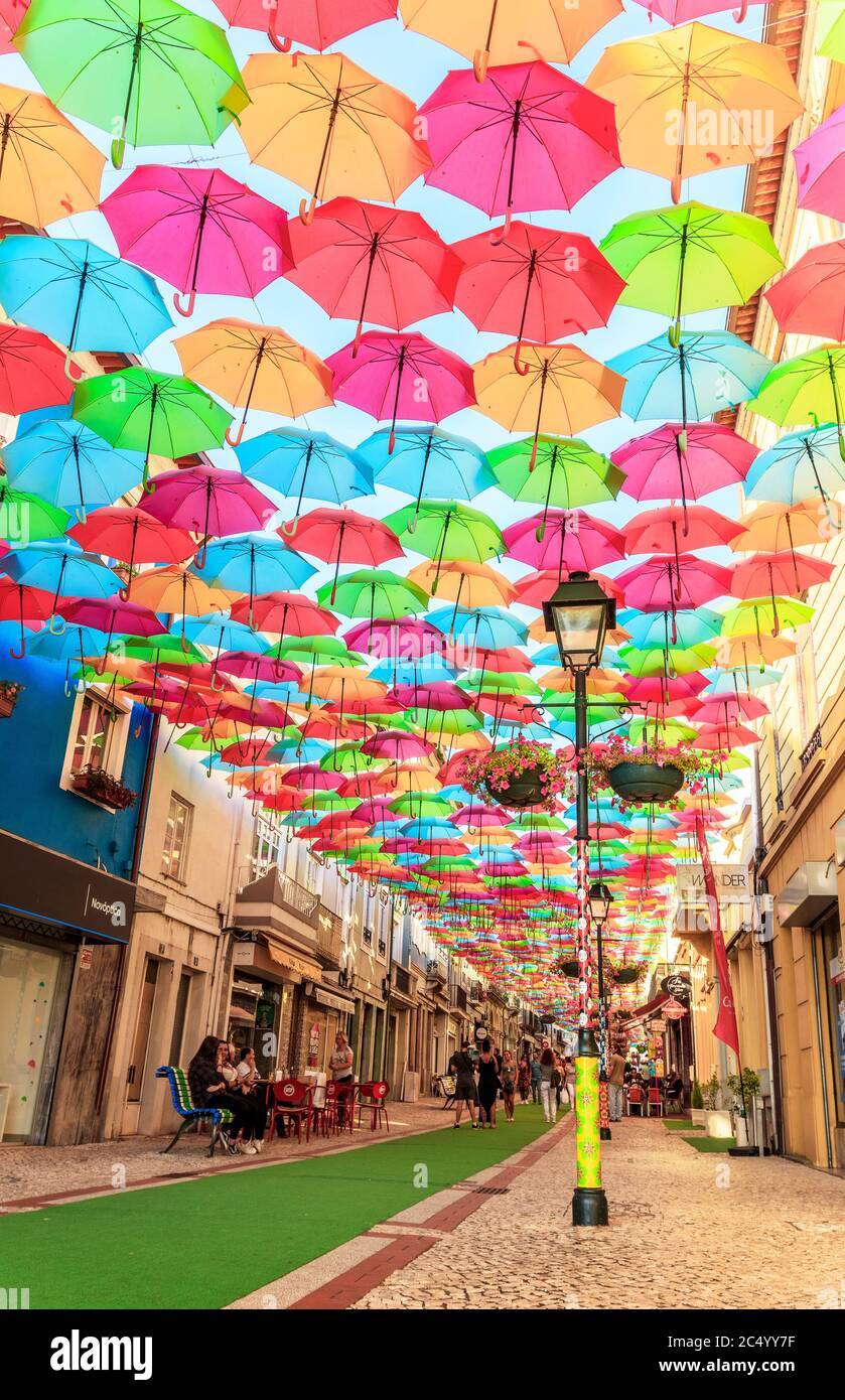 Calle cubierta por paraguas de multiples colores en Portugal