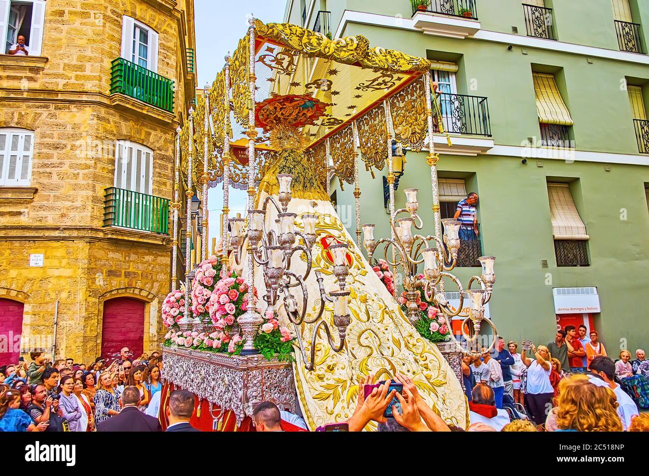 CÁDIZ, ESPAÑA - 22 DE SEPTIEMBRE de 2019: Partisipants de Mercedes Fiesta (Festival nuestra Señora de la Misericordia) camina por la calle, llevando velas, palanquin canoped Foto de stock