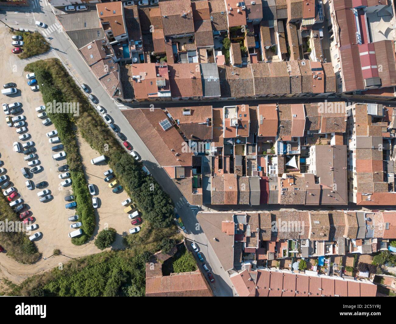 Imagen de drone de un tiro aéreo de arriba abajo de una zona urbana en una pequeña ciudad al lado de algunos árboles. Foto de stock