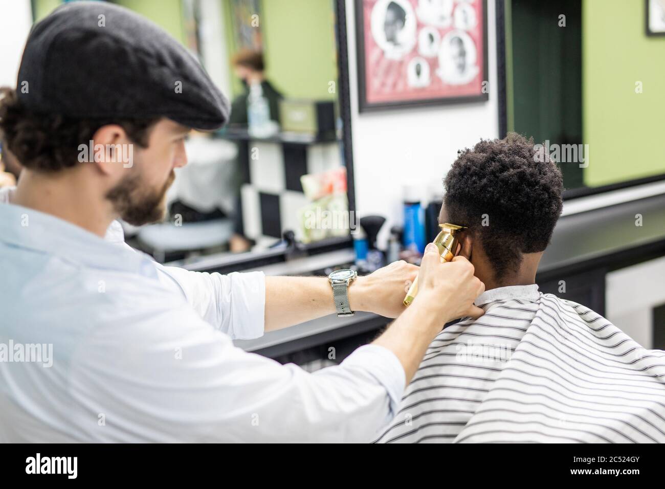limpiar Redondear a la baja Poner a prueba o probar Barbero profesional hace nuevo corte de pelo con máquina de afeitar  eléctrica.joven hombre negro recivie nuevo corte de pelo en barbershop  Fotografía de stock - Alamy