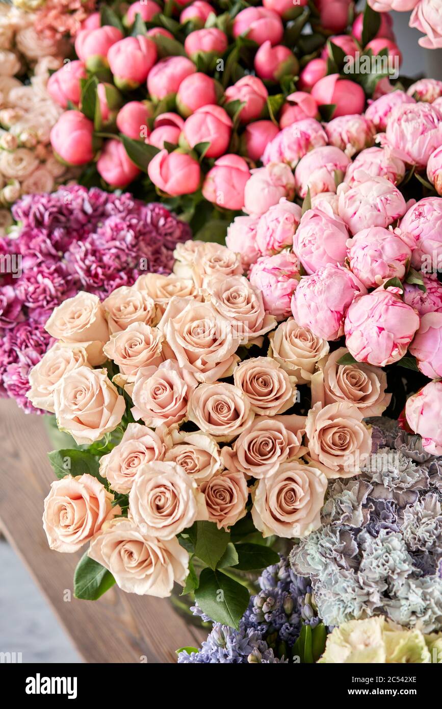 Muchos colores diferentes en el stand o mesa de madera en la tienda de flores. Escaparate. Fondo de mezcla de flores. Flores hermosas para catálogo o en línea Foto de stock