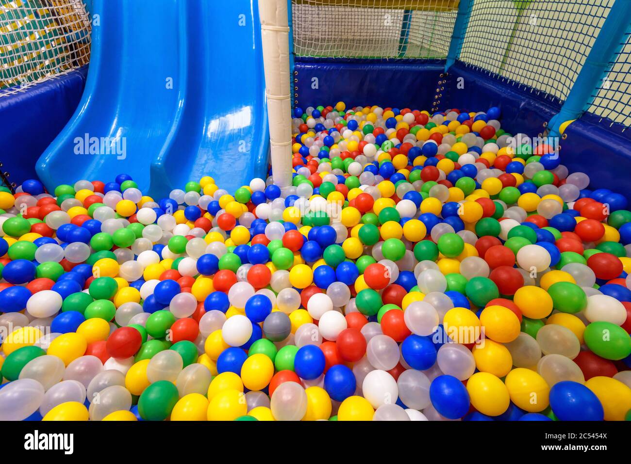 Parque infantil para el deporte y el juego en el jardín de infantes. Dentro  de la piscina seca de plástico con bolas de colores y tobogán. Un buen  gimnasio para niños para