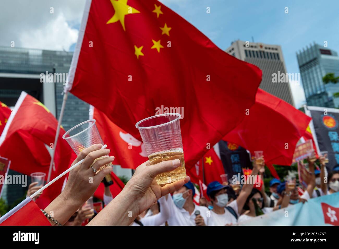 Los partidarios de China se reúnen y celebran con banderas y champán en Tamar Park horas después de que el gobierno chino y la jefa ejecutiva de Hong Kong, Carrie Lam, aprobaran la Ley de Seguridad Nacional en Hong Kong. Foto de stock