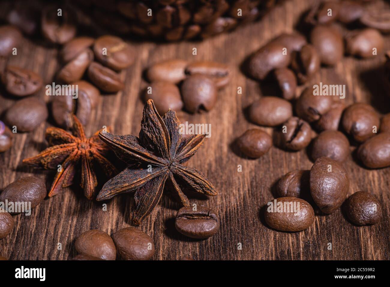 Fondo para granos de café en colores oscuros para el fondo. Café granos de café Canela Palo de Canela Estrella de Anise Mesa de madera primer plano. Foto de stock
