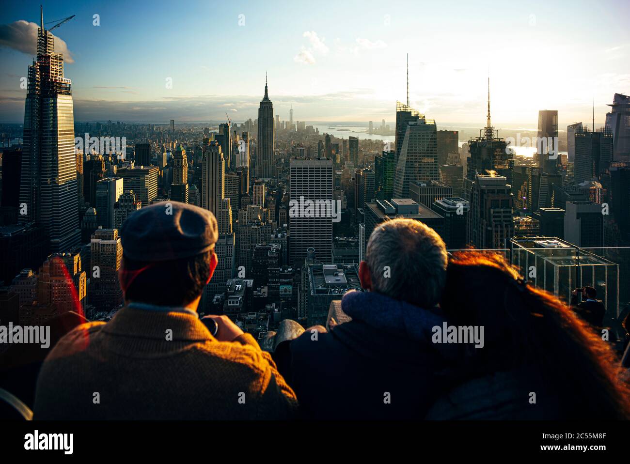 La gente observa desde los rascacielos los edificios de Nueva York al atardecer y toma fotos con el móvil, Estados Unidos Foto de stock