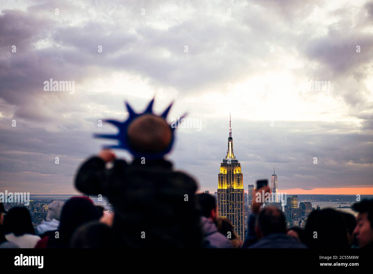 La gente observa desde los rascacielos los edificios de Nueva York al atardecer y toma fotos con el móvil, Estados Unidos Foto de stock