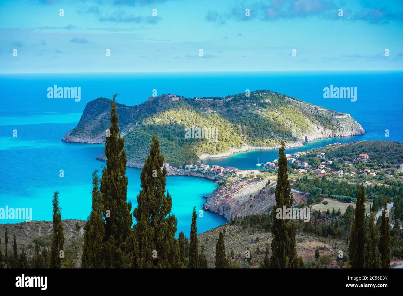 Assos pueblo y costa de hermoso mar azul. Ciprés en primer plano. Isla de Kefalonia, Grecia. Foto de stock