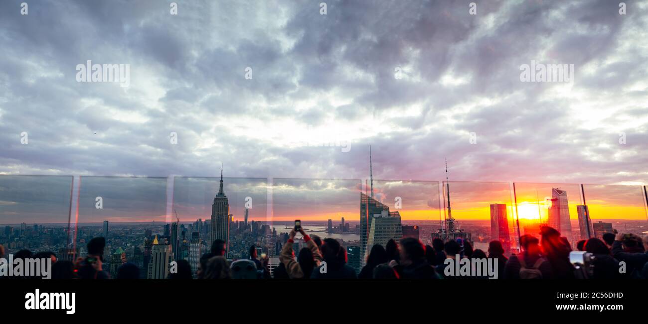 La gente observa desde los rascacielos los edificios de Nueva York al atardecer y. Foto de stock