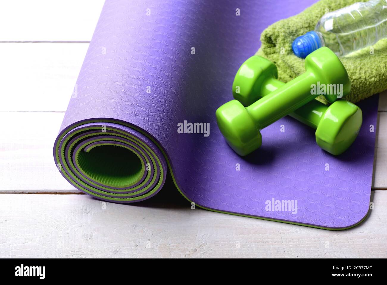 https://c8.alamy.com/compes/2c577mt/mancuernas-de-plastico-verde-sobre-fondo-de-madera-clara-deporte-y-estilo-de-vida-saludable-equipos-de-entrenamiento-y-entrenamiento-barbells-cerca-de-una-botella-de-agua-y-toalla-suave-tumbada-en-una-alfombra-de-yoga-purpura-2c577mt.jpg