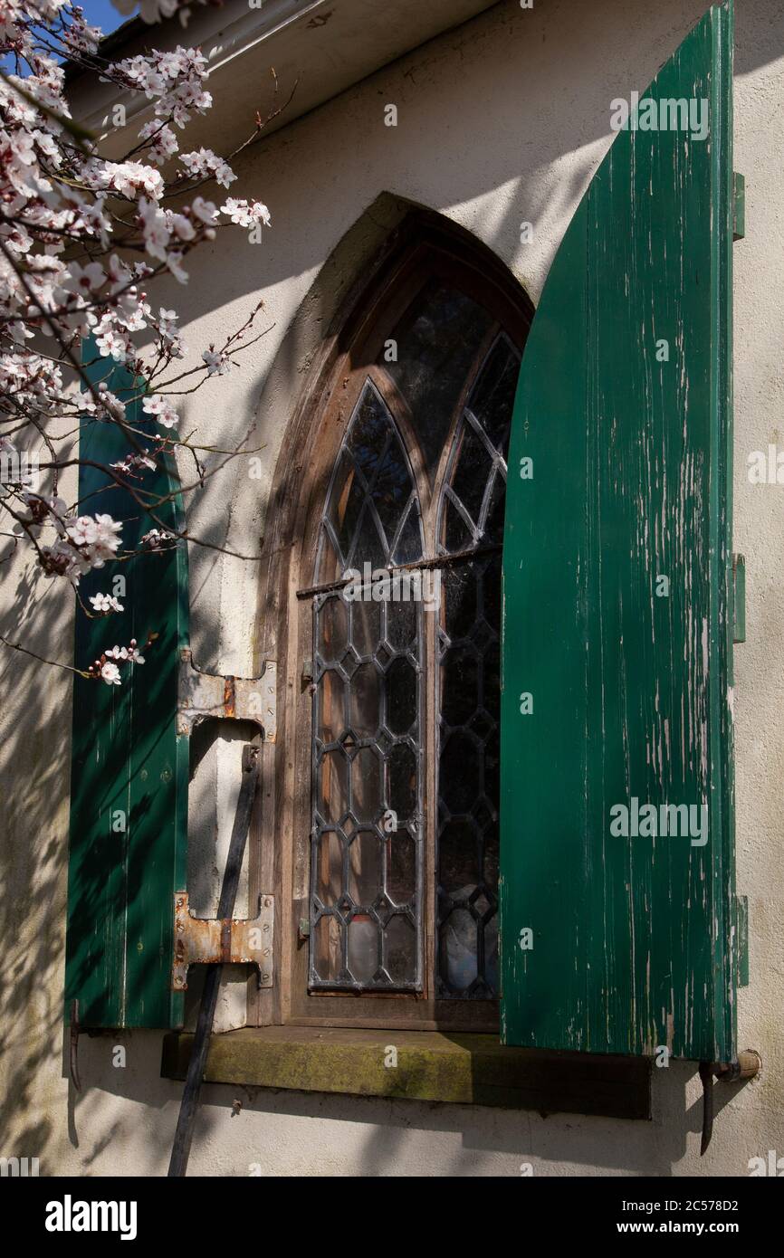 Ventana gótica arqueada y persianas en la casa Foto de stock