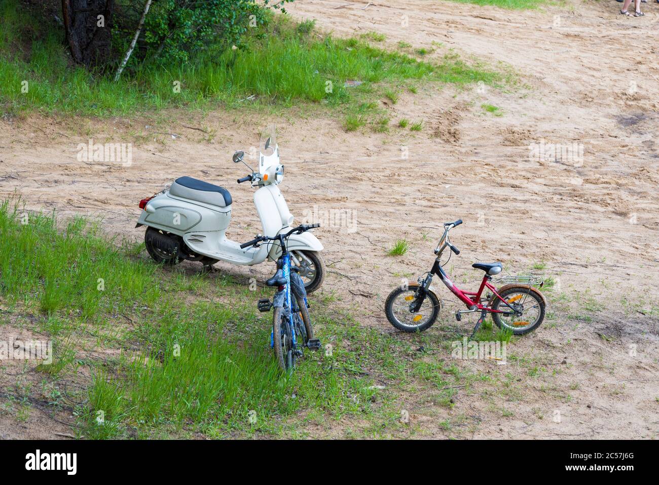 Un viejo ciclomotor de época y dos bicicletas están en la arena. Equipo de época. Foto de stock