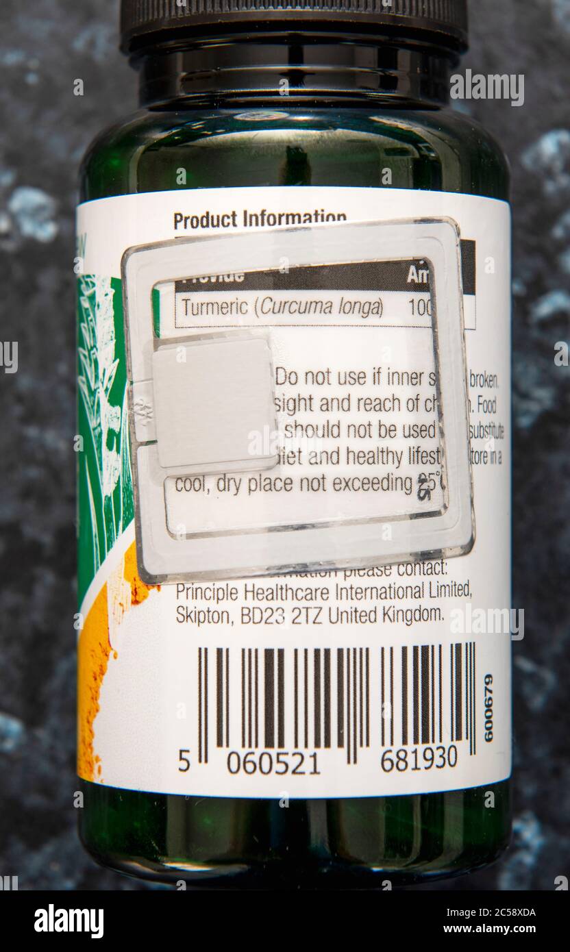 Pequeño producto en botella con una etiqueta electrónica de seguridad adjunta.UK Foto de stock