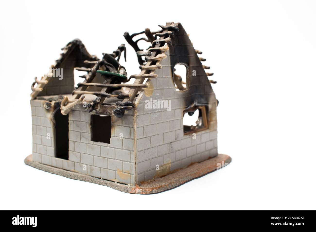 Una casa en miniatura que es quemada por un fuego real. Peligros de un incendio. Foto de stock
