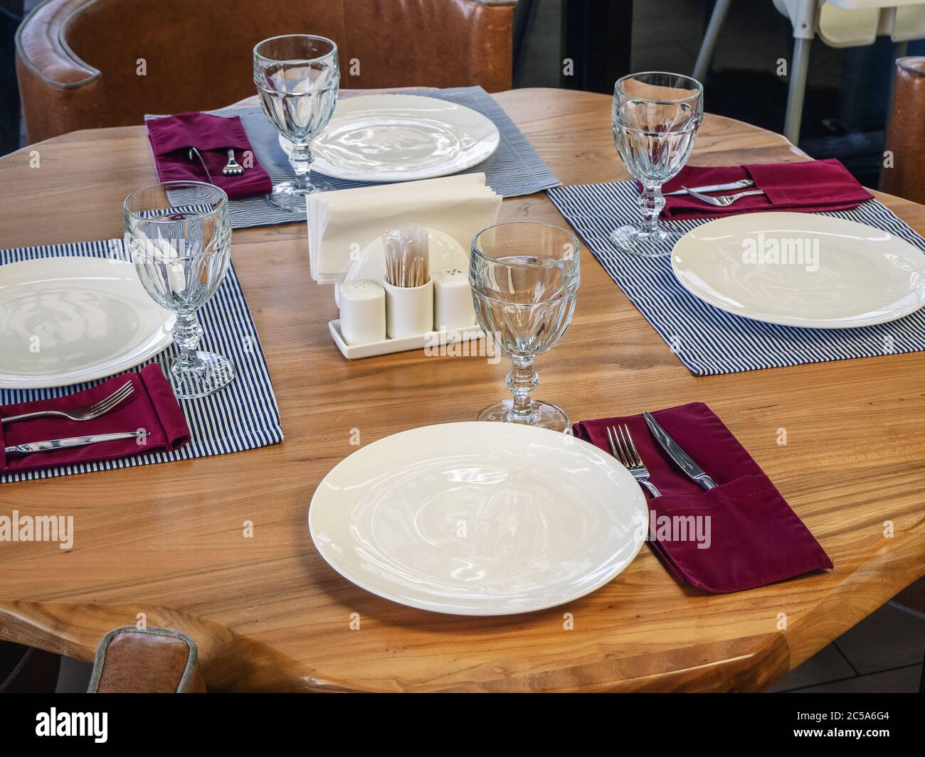 Una mesa con tres cubiertos de pie sobre servilletas a rayas y un  dispositivo sin ella. Ajuste de mesa para cuatro personas. Foto de primer  plano Fotografía de stock - Alamy