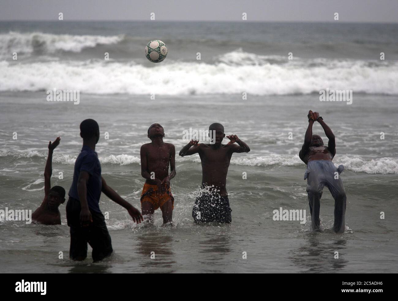 Ghana, Accra, Jamestown. Un grupo de chicos bañándose después de jugar al  fútbol en la playa de Jamestown pueblo pesquero. Parte de la costa del mar  en Jamestown Fotografía de stock -