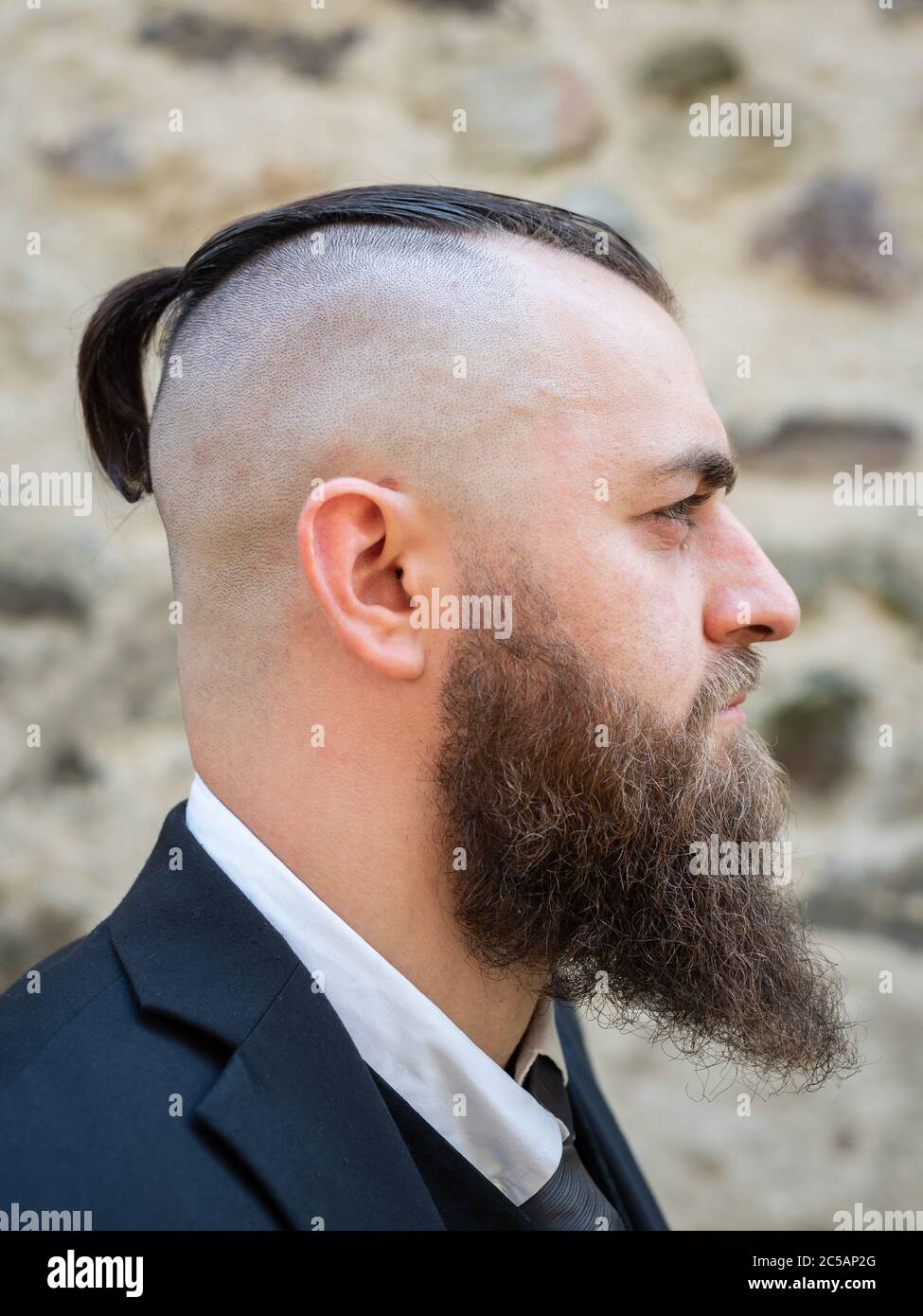 Perfil retrato de un hombre con una barba larga y un corte de pelo corto en  ropa elegante Fotografía de stock - Alamy