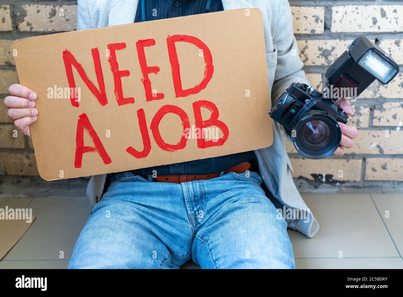 Desempleados durante la crisis. Hombre blanco sosteniendo un cartel en sus  manos buscando trabajo. Fotógrafo sin trabajo Fotografía de stock - Alamy