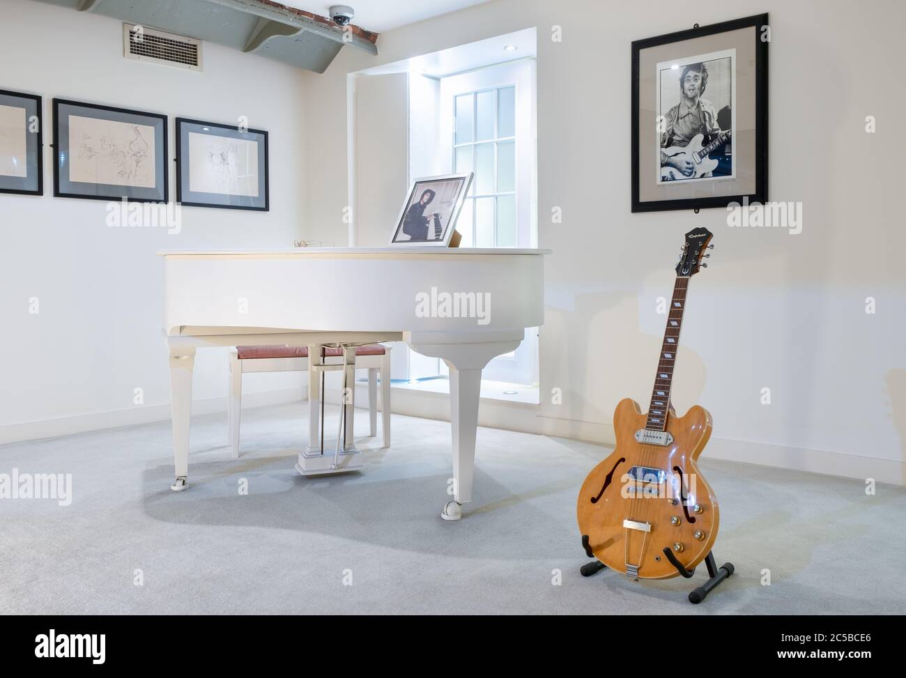 Habitación con el famoso piano blanco que se utiliza para tocar Imagine y  una guitarra propiedad de John Lennon en la exposición Beatles Story en  Liverpool Fotografía de stock - Alamy