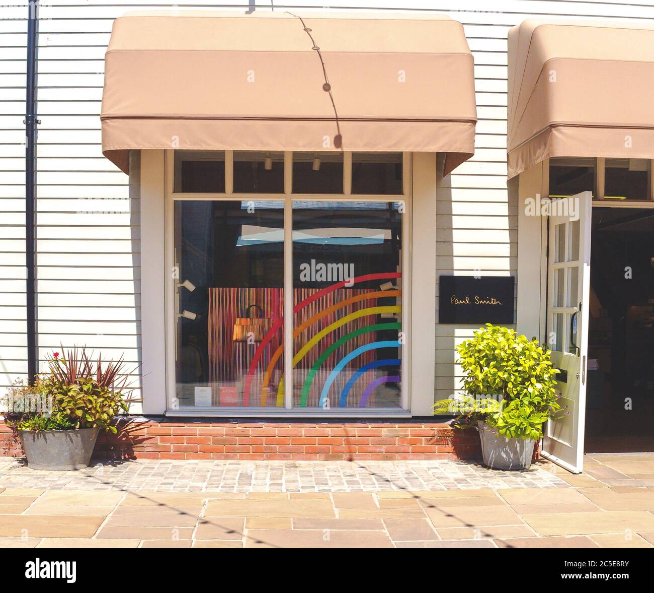 La unidad comercial Paul Smith vuelve a abrir en Bicester Village. Una pantalla de ventana de arco iris conmemora el mes del orgullo Gay y el apoyo de los trabajadores clave durante el covid. Foto de stock