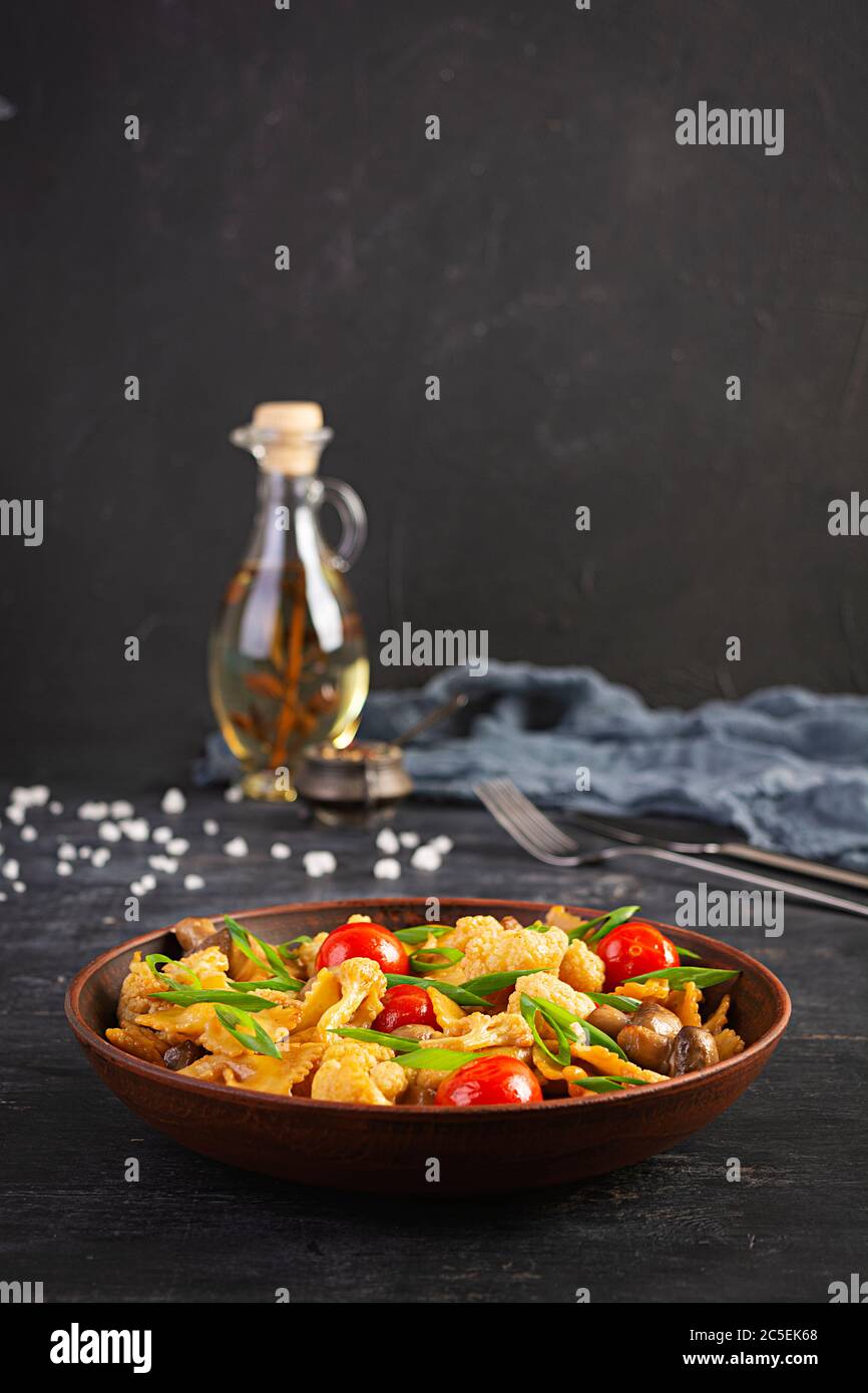 Revuelva la pasta farfalle con verduras, coliflor y champiñones Foto de stock