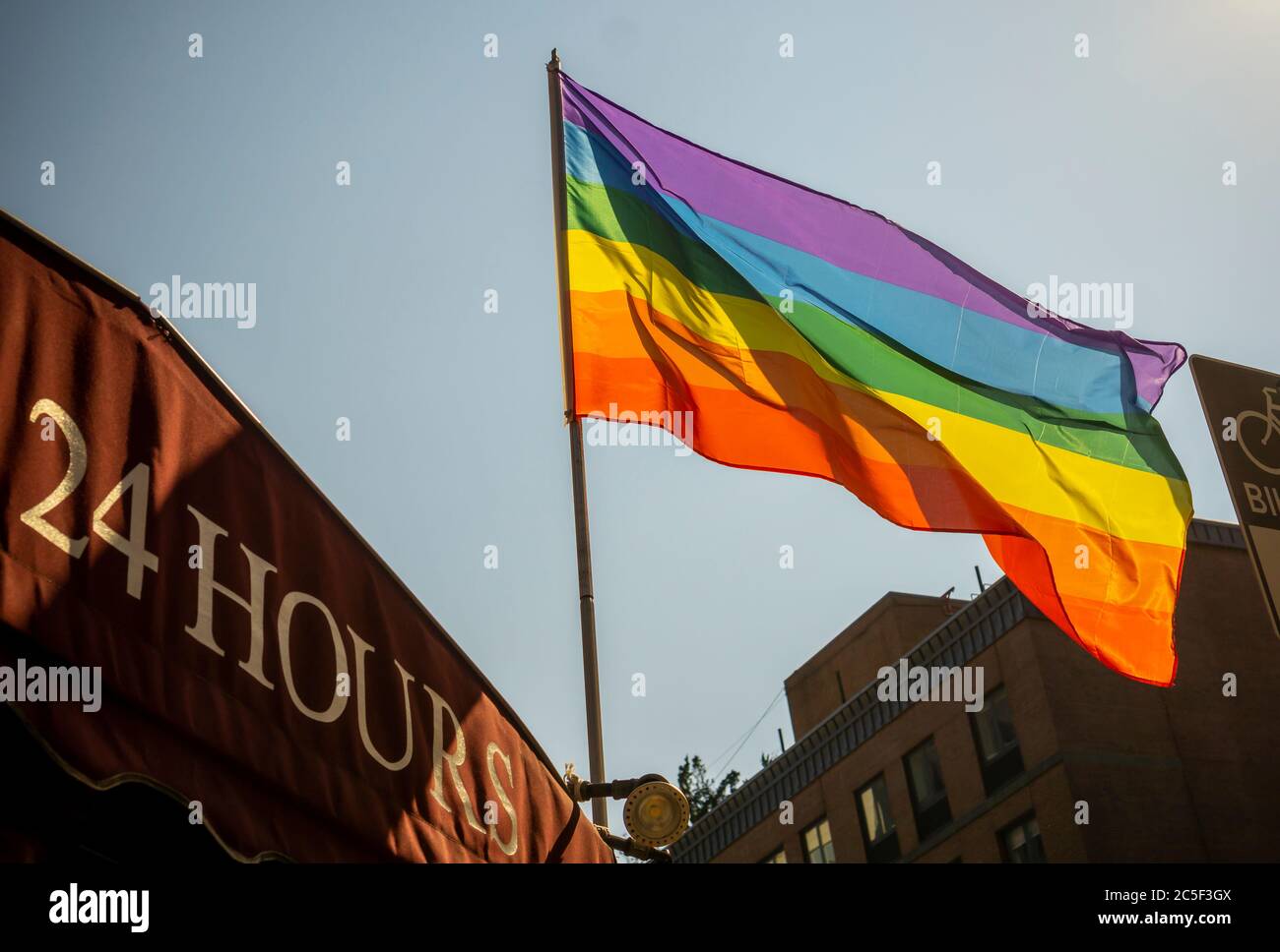 Una bandera del arco iris vuela de un negocio en Nueva York el martes, 23 de junio de 2020. Debido a la pandemia de covid-19, el desfile del orgullo LGBTQ de este año, así como todas las otras grandes reuniones, han sido canceladas o pospuestas. (© Richard B. Levine) Foto de stock