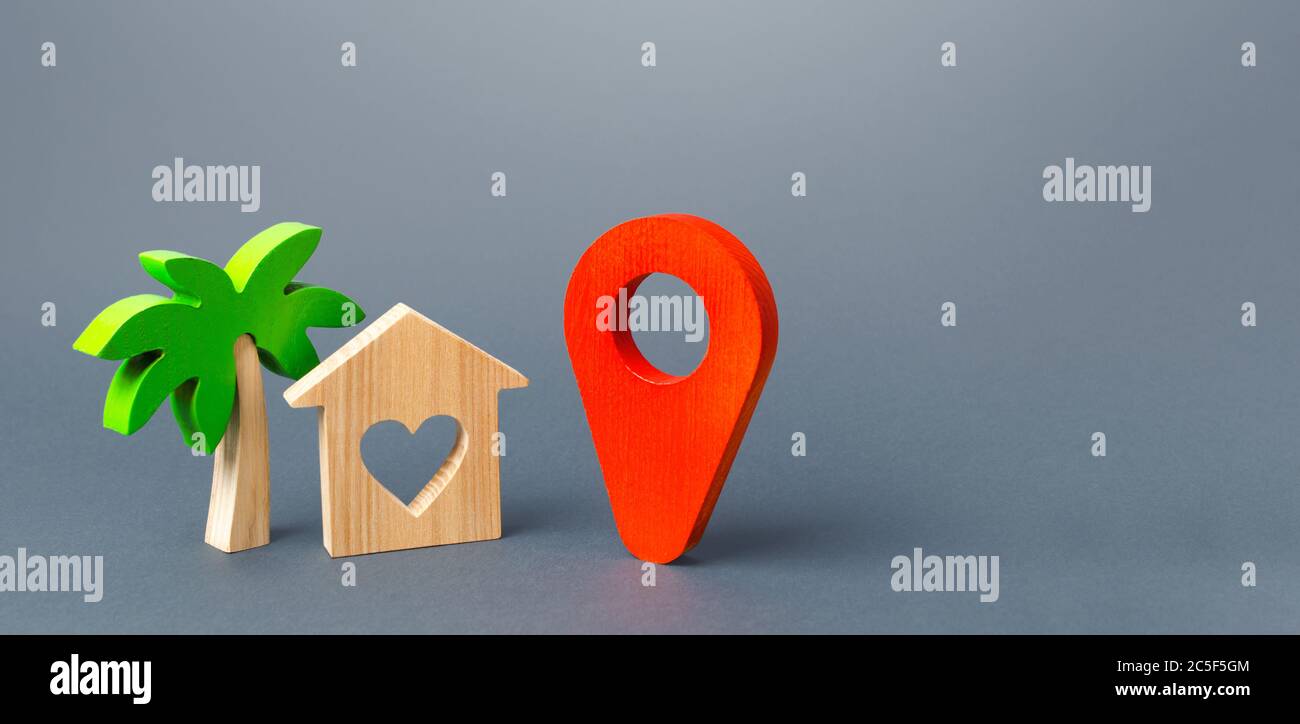 Casa con un corazón y un puntero de navegación rojo. Elegir un lugar para un viaje romántico. Una guía turística en el mundo post-pandemia. Nuevas reglas para t Foto de stock