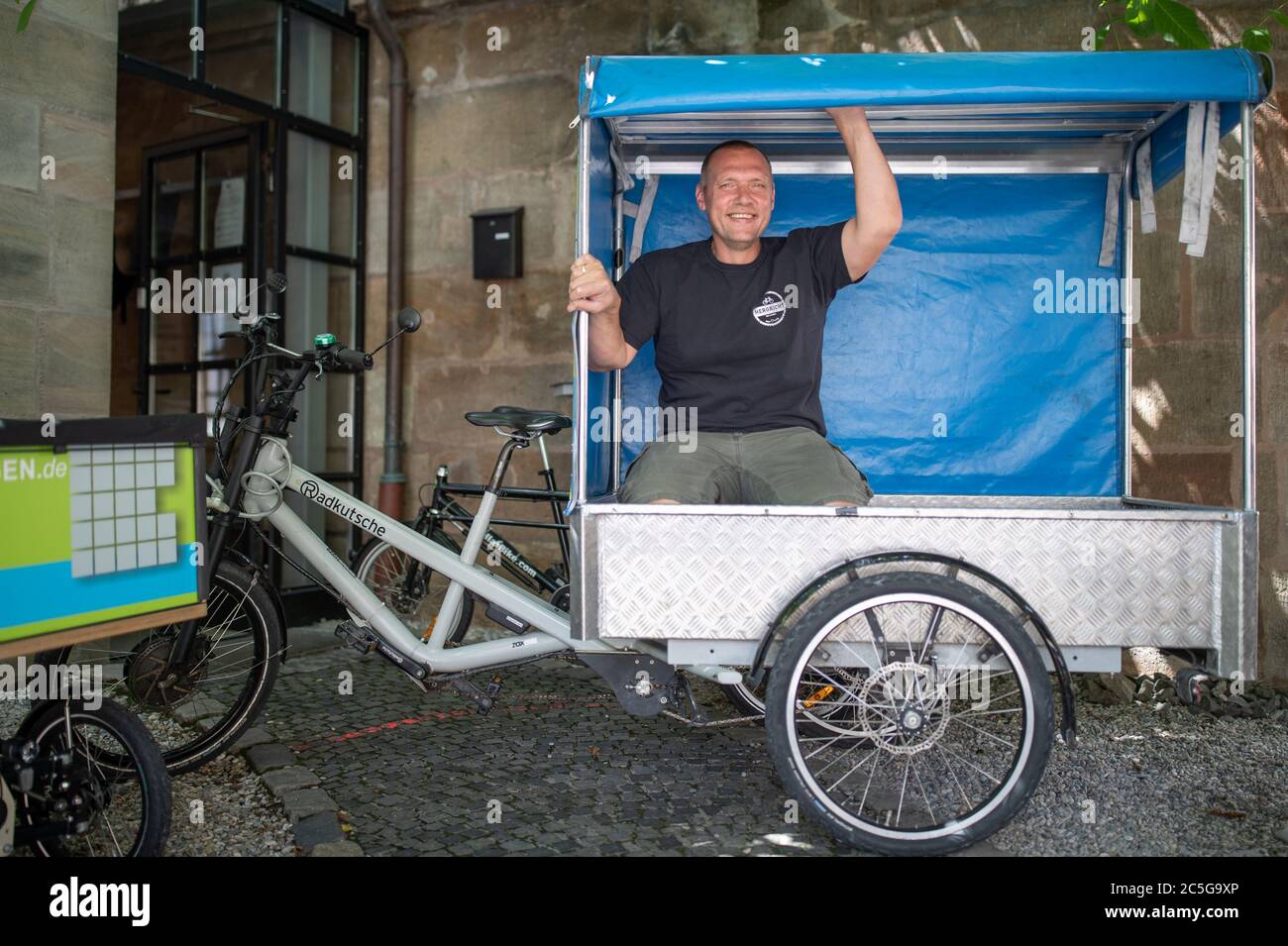 Nuremberg, Alemania. 30 de junio de 2020. Andreas Reisch de Cafe Hergricht,  una empresa de alquiler de bicicletas de transporte, se sienta en un  remolque de una bicicleta de carga eléctrica para