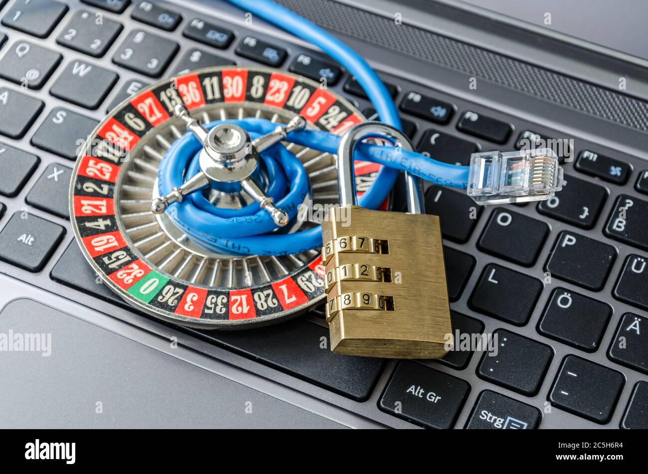 Rueda de la ruleta, candado y cable de Internet en el teclado del ordenador que simboliza la codificación de datos Foto de stock
