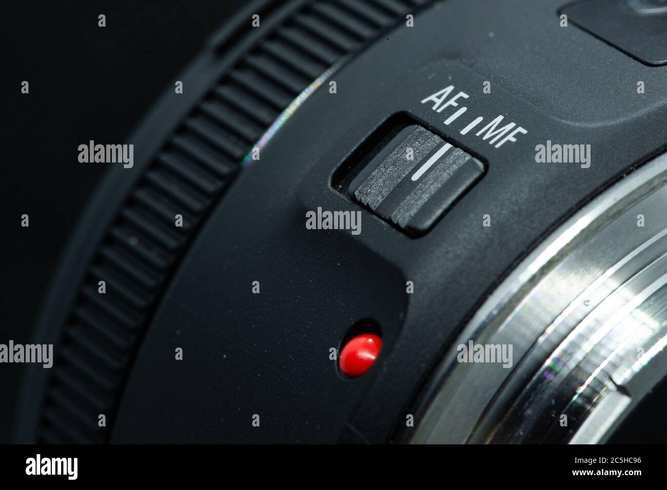 Macro Foto de primer plano de la lente a la cámara dslr sobre fondo oscuro vista de punto rojo y anillo de extensión plateado y botón de enfoque automático. Foto de stock