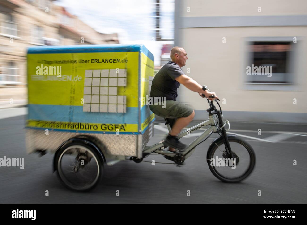 Nuremberg, Alemania. 30 de junio de 2020. Andreas Reisch de Cafe Hergricht,  una empresa de alquiler de bicicletas de transporte, se sienta en un  remolque de una bicicleta de carga eléctrica para la comparación de tamaño.  Se supone que las bicicletas ...