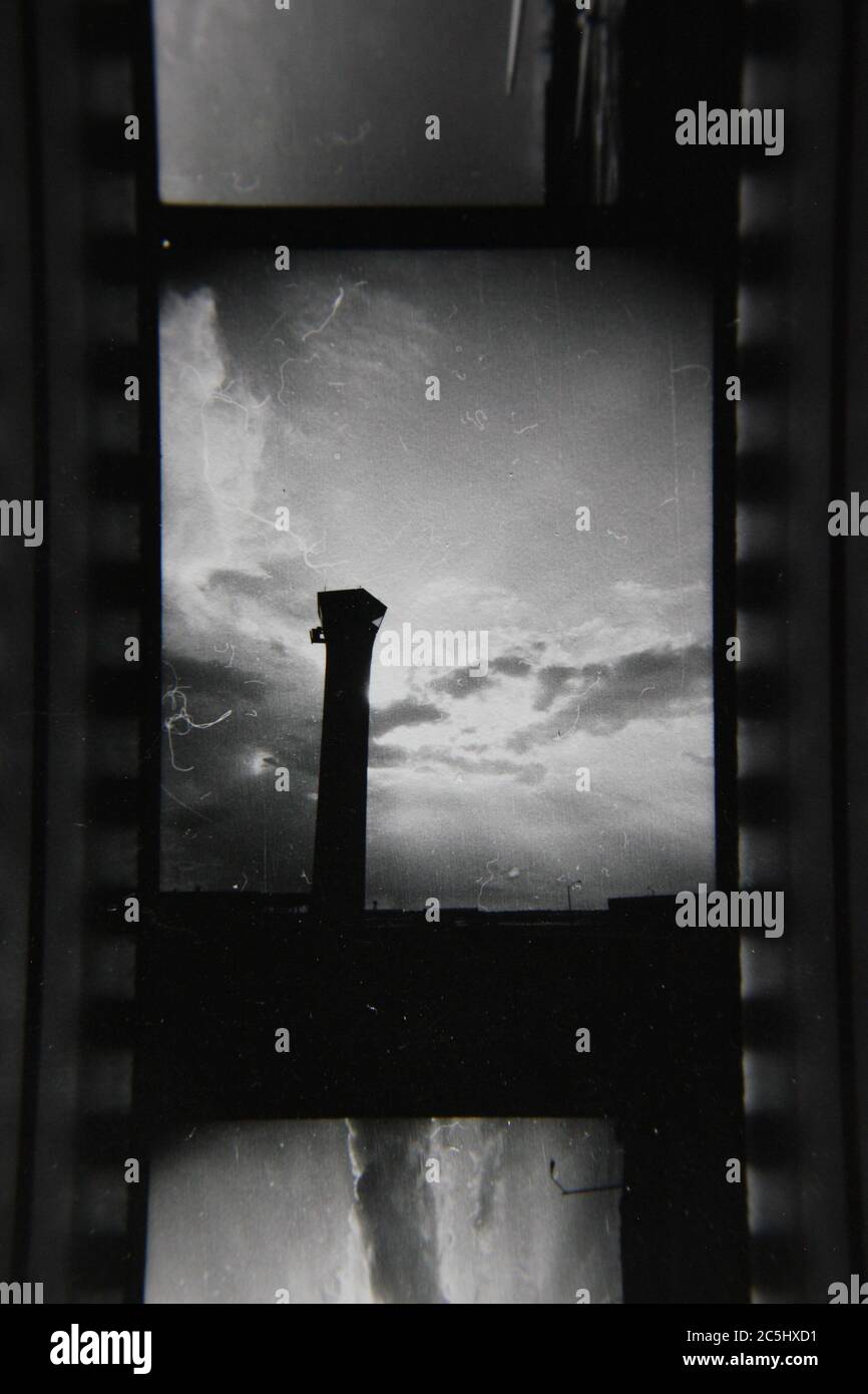 Foto en blanco y negro de la torre de control del tráfico aéreo en el hermoso cielo nublado. Foto de stock