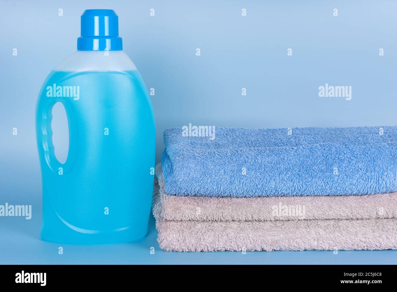 Botella de detergente con toallas limpias sobre fondo azul. Recipiente de  producto de limpieza, productos químicos domésticos. Detergente líquido, día  de lavandería, limpieza Fotografía de stock - Alamy