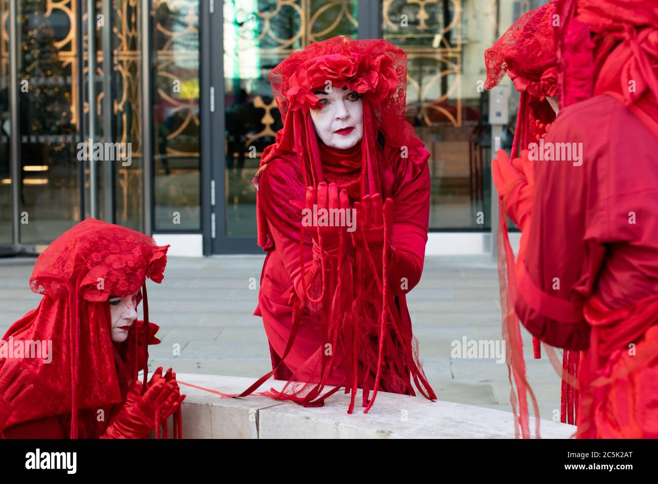 Ataque climático global en la Plaza de San Pedro, Manchester, Reino Unido. Extinción rebelión los rebeldes rojos del circo invisible se reúnen alrededor de la base de Emmeline Pankhurst. Foto de stock