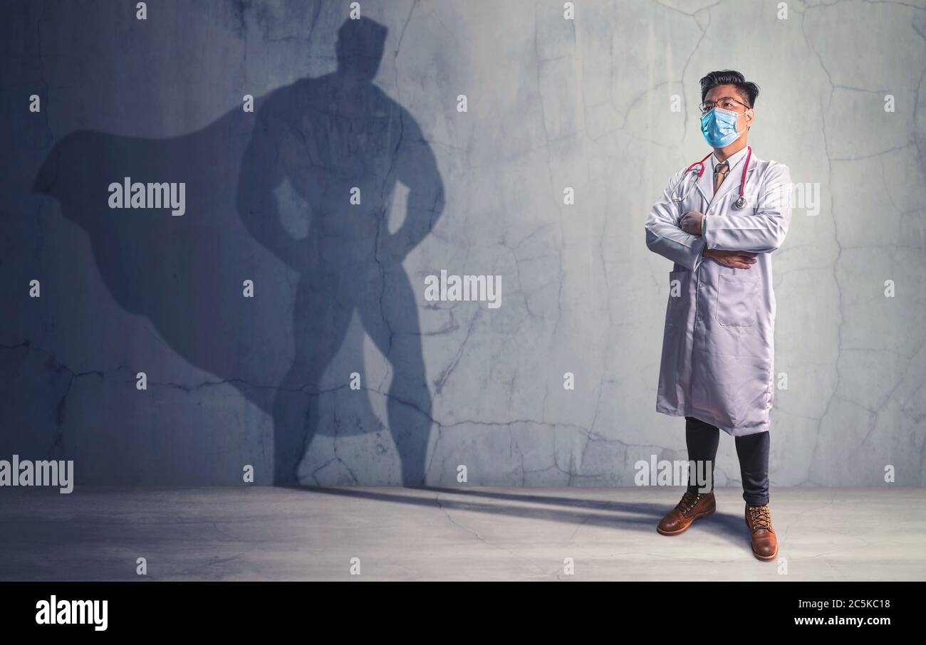 Médicos valientes con su sombra de superhéroe en la pared. Concepto de hombre poderoso Foto de stock