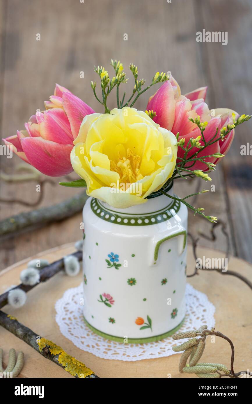 ramo de primavera con tulipanes en amarillo y rojo en jarrón Foto de stock