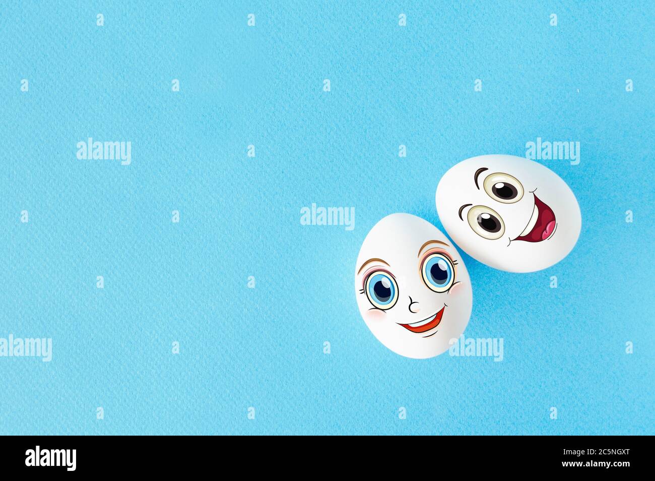 Pareja huevos con el concepto de cara feliz por amor, fondo azul con espacio vacío Foto de stock
