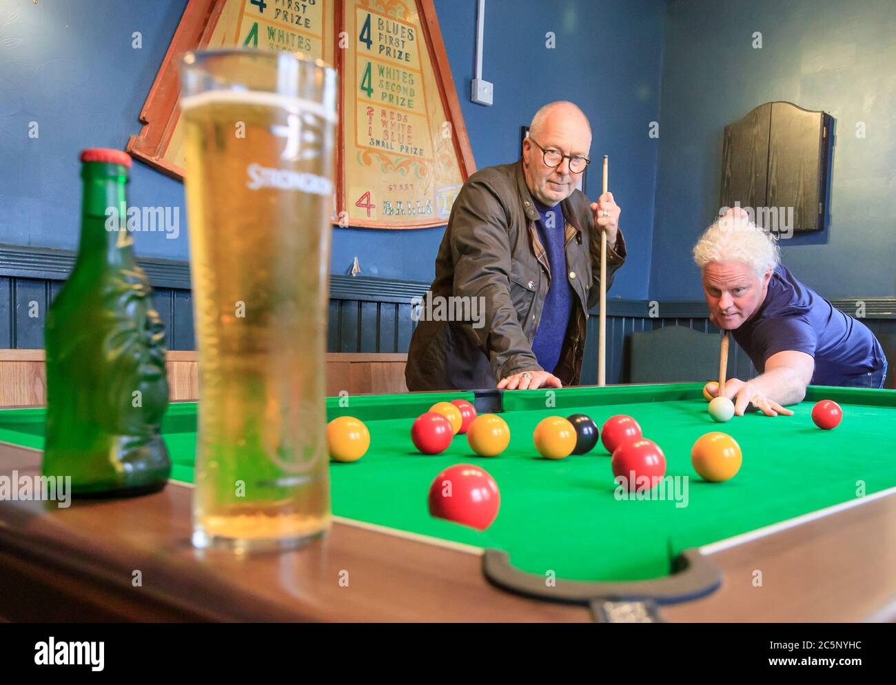 Un cliente juega en el pub Golden Lion en Todmorden, West Yorkshire, mientras vuelve a abrir tras la relajación de las restricciones de bloqueo de coronavirus en toda Inglaterra. Foto de stock