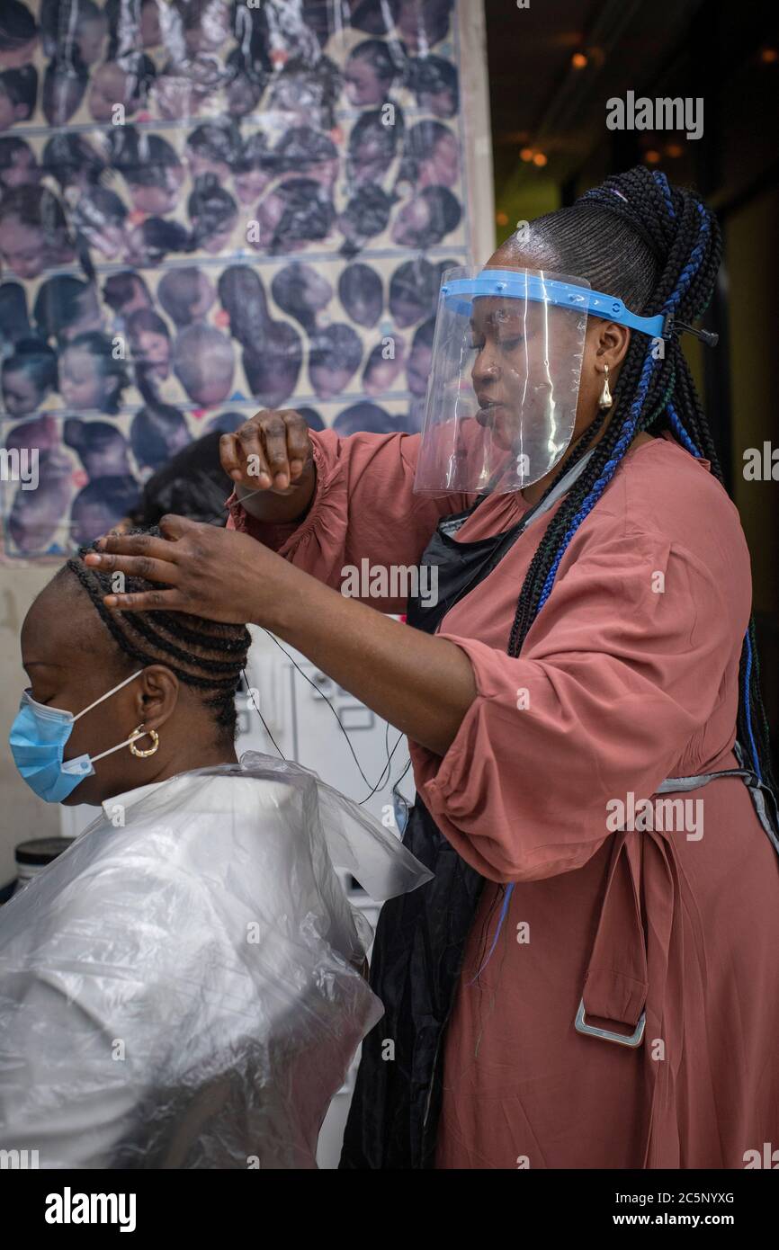 Peckham, Inglaterra. 4 de julio de 2020. Una mujer que tenía su pelo trenzado y trenzado en el salón de peluquería estilo en Peckham en los salones de día reabrir habiendo sido cerrado durante más de tres meses en el Reino Unido debido a la pandemia de coronavirus. (Foto de Sam Mellish / Alamy Live News) Foto de stock